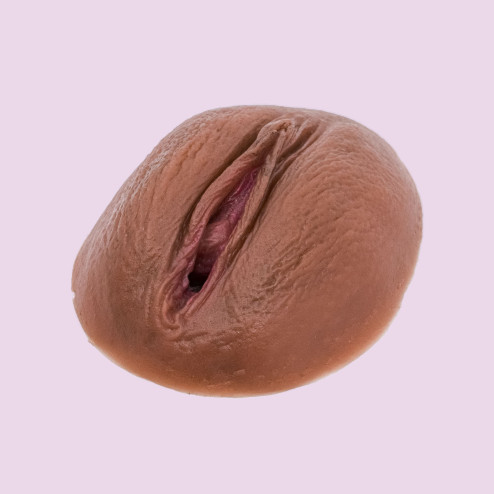 Vulve pêche en silicone foncé sur fond rose à la location