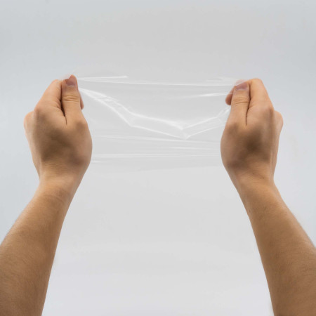 préservatif buccal en polyuréthane tenu par deux main